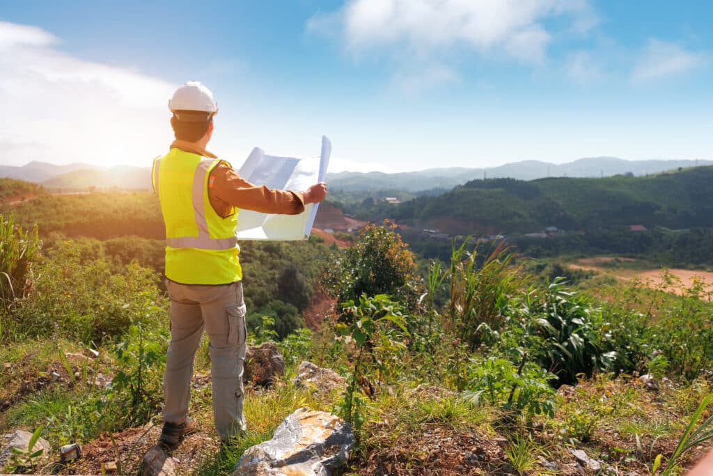 Land surveyor reviewing plans on site